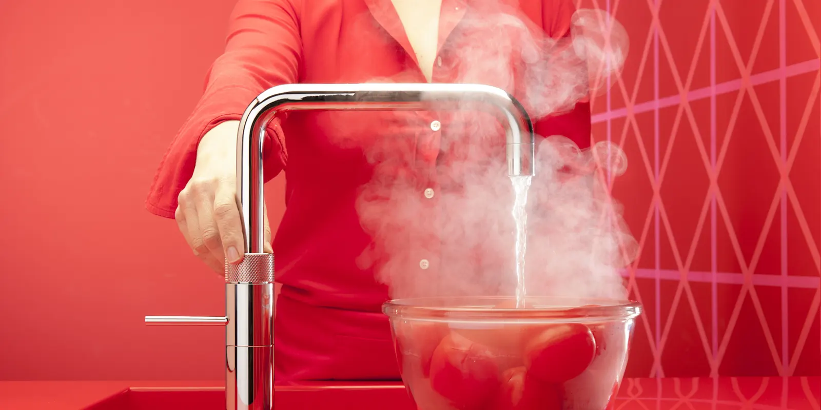 Eau bouillante s'écoulant d'un robinet à eau bouillante moderne dans une casserole, symbolisant la vulnérabilité à l'accumulation de calcaire